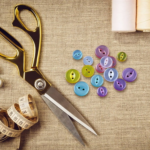 Una colección de accesorios de costura que incluye un botón, botones y  otros materiales de costura.