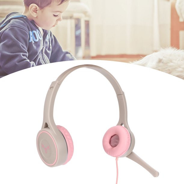 Bebé con auriculares escuchando música en una cama blanca en casa