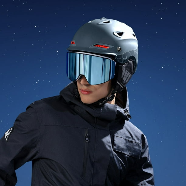 Mujer con ropa de esquí con casco y gafas de esquí en la cabeza