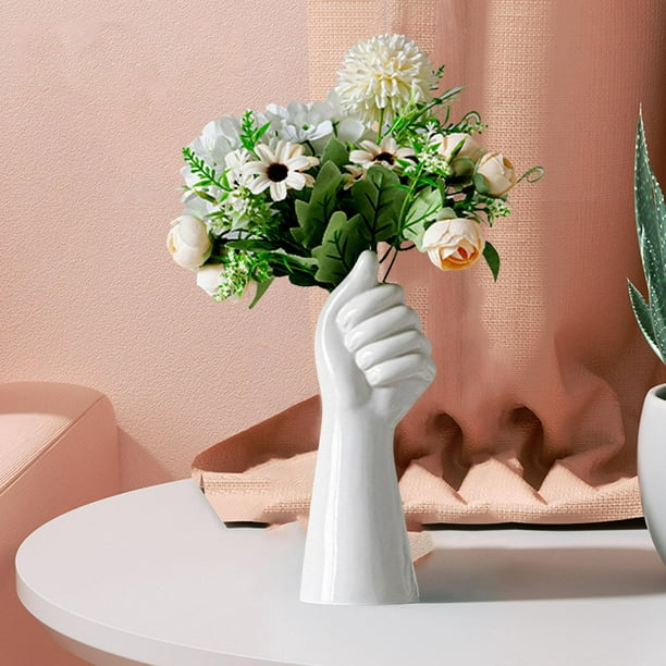Flores artificiales en jarrones de cerámica blanca sobre la
