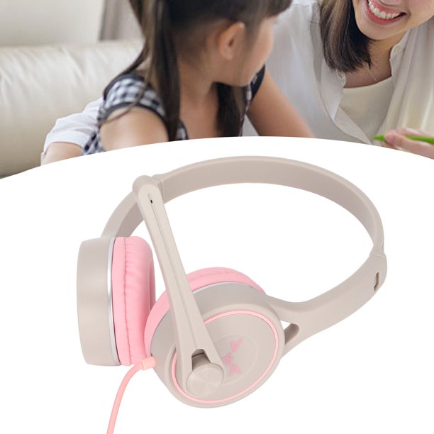 Bebé con auriculares escuchando música en una cama blanca en casa