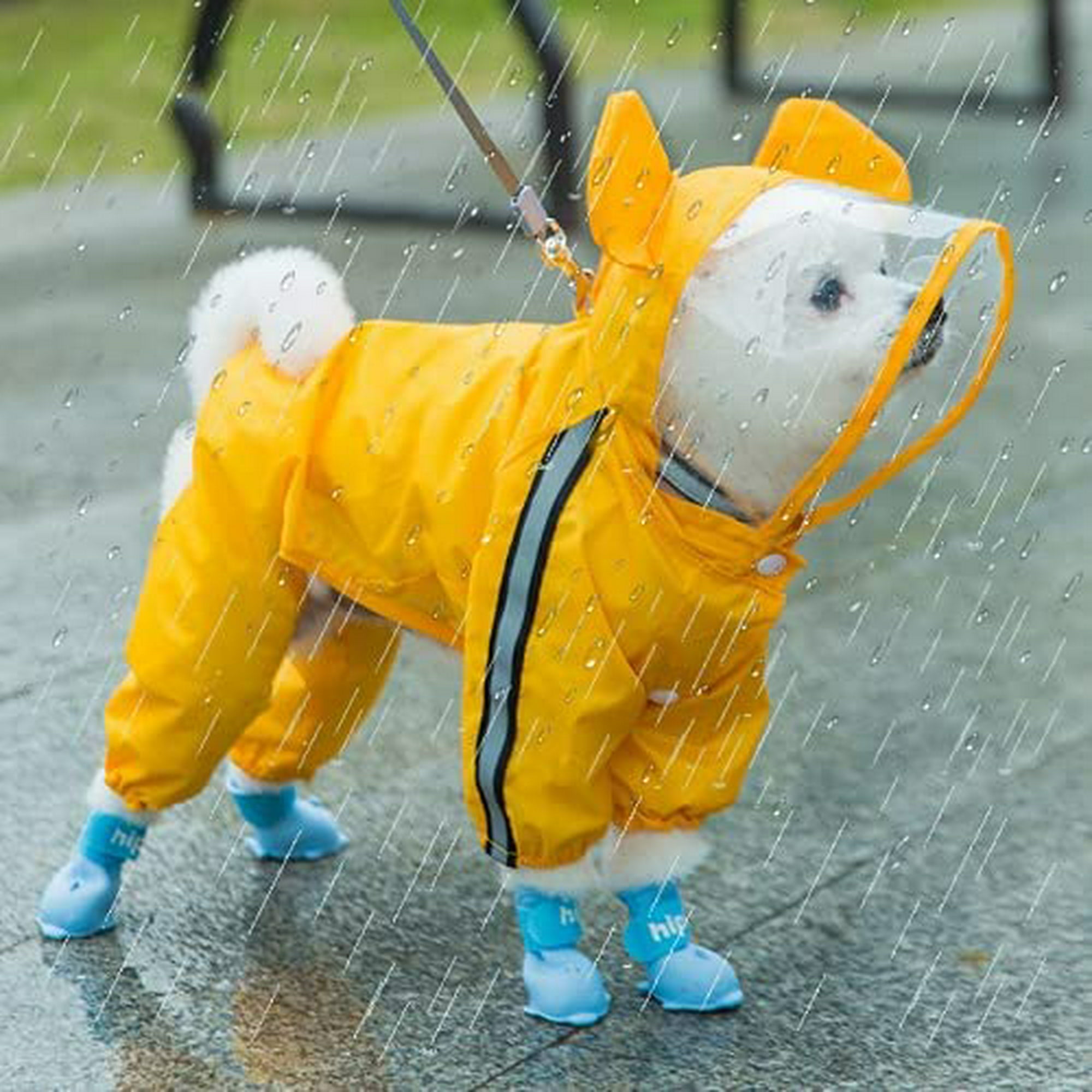 Niño con capa impermeable amarilla y botas jugando al aire libre después de  la lluvia