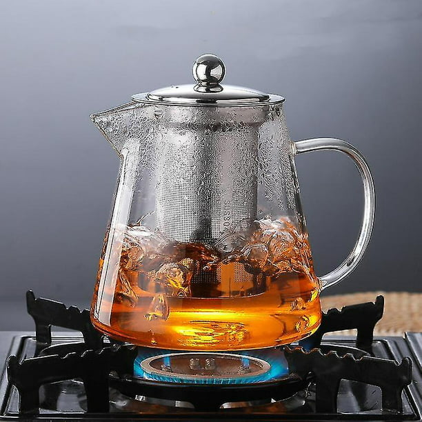 Tetera de cristal con té en una bandeja con el primer de las tazas.