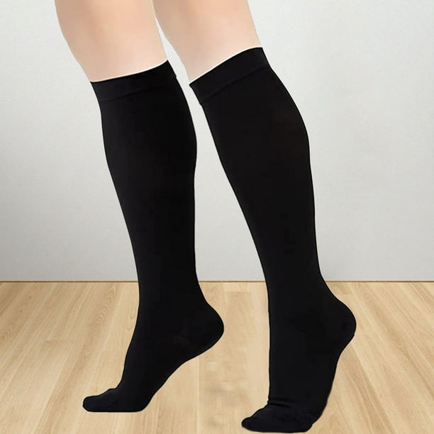 Un par de piernas de hombre con calcetines blancos con fondo negro.