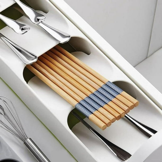Mueble de cocina blanco con cajón abierto con bandeja organizadora de  cubiertos negra con tenedores, cucharas, cuchillos y otros accesorios  plateados. sistema de organización de almacenamiento de cocina