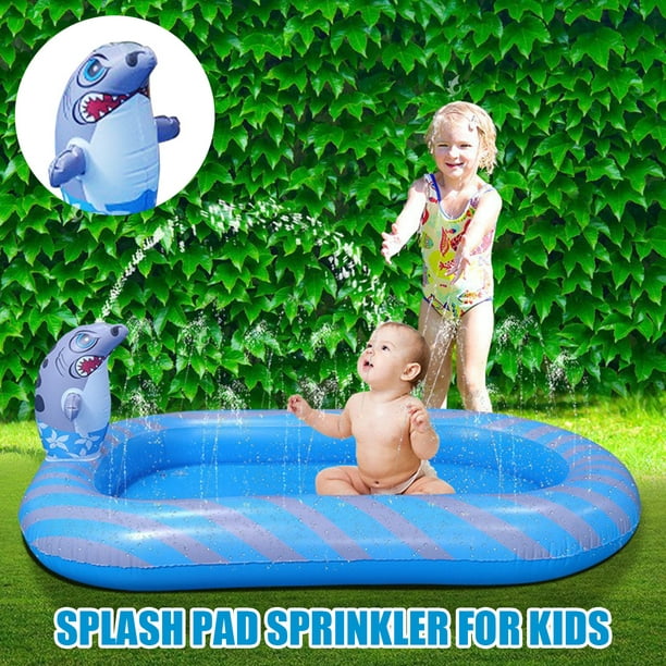 Adorable niña de 5 años en un traje de baño de moda sopla burbujas de jabón  en la piscina inflable para niños en el jardín de la casa